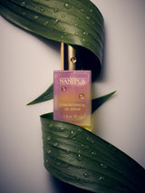 Nanipua ethnobotanical oil serum bottle on a leaf with water droplets