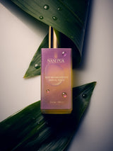 NANIPUA hair oil bottle on a leaf with a gradient purple label