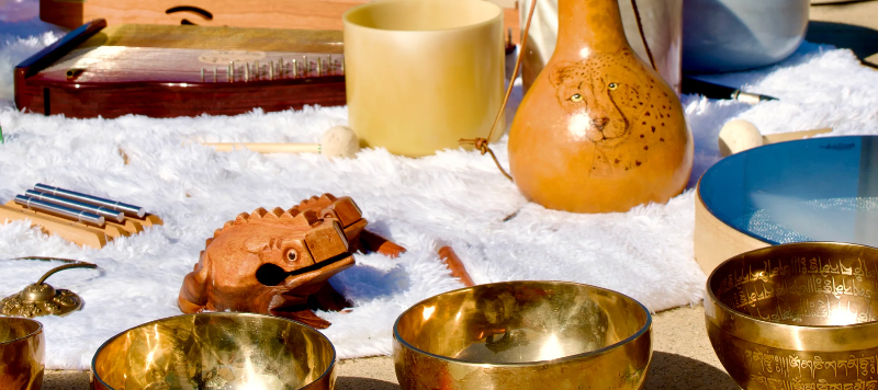 Collection of singing bowls and gongs on a snowy surface